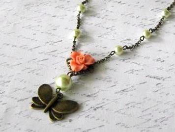 Romantic antiqued bronze butterfly necklace with greenish glass pearls and light orange resin flower